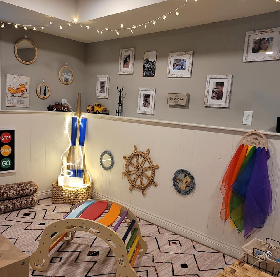 Play corner with rainbow climbing frame, fairy lights, and ship wheel