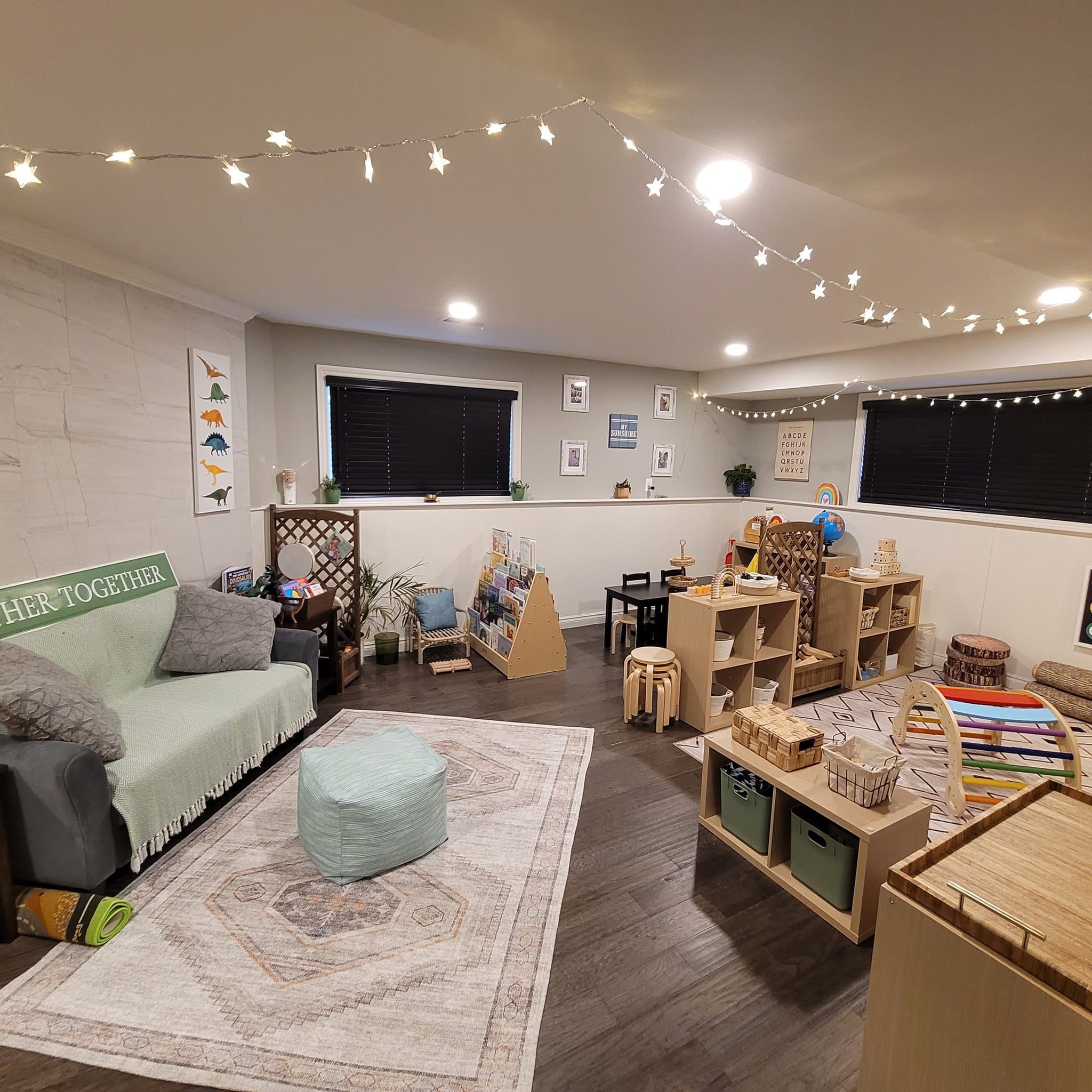 Curiosity's Child main play room with star lights, natural wood furniture, and cosy reading area